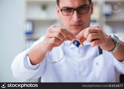 Male doctor in anti-smoking conceptwithcigarette pack