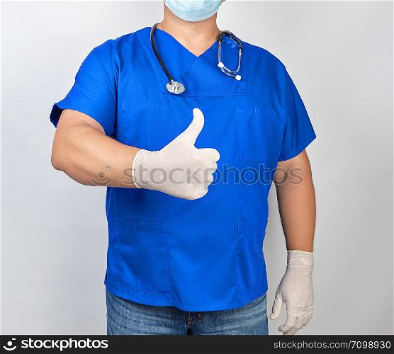 male doctor in blue uniform and latex white gloves shows right hand gesture like, thumb raised up
