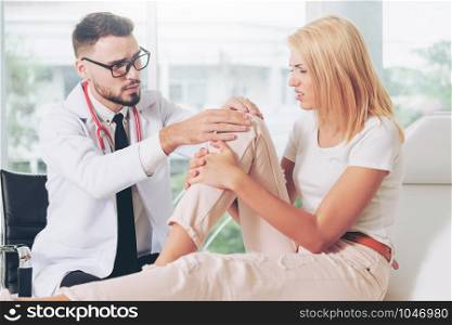 Male doctor is examining female patient in hospital ward. Healthcare and medical service.