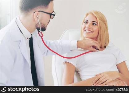 Male doctor is talking and examining female patient in hospital office. Healthcare and medical service.. Male Doctor and Female Patient in Hospital Office