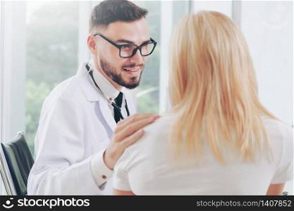 Male doctor is talking with female patient in hospital office. Healthcare and medical service.. Male Doctor and Female Patient in Hospital Office