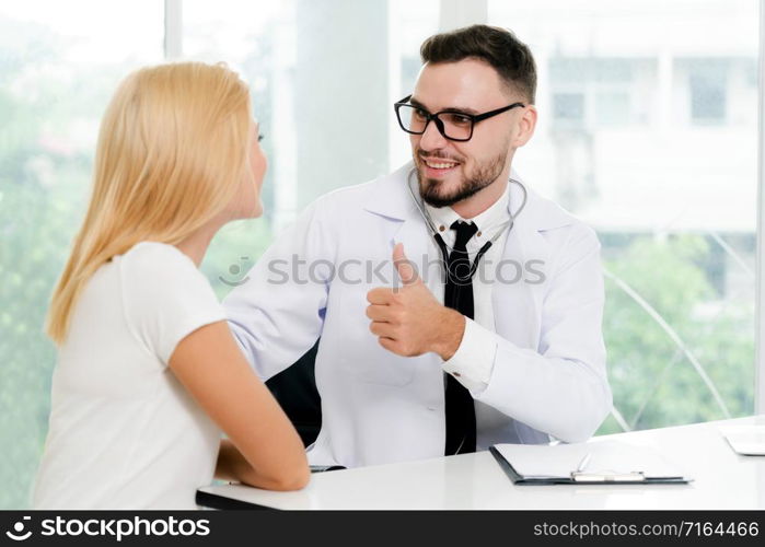 Male doctor is talking with female patient in hospital office. Healthcare and medical service.. Male Doctor and Female Patient in Hospital Office