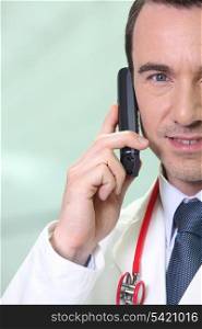 Male doctor making telephone call