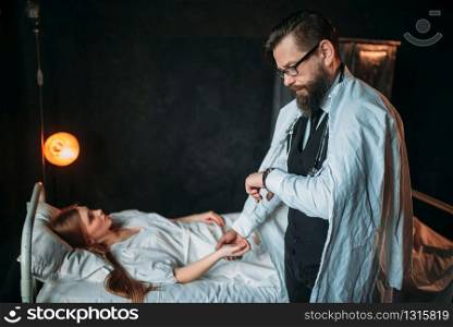 Male doctor measures the pulse of young sick woman in the hospital. Illness of female patient in clinic, health recovery and treatment. Male doctor measures the pulse of young sick woman