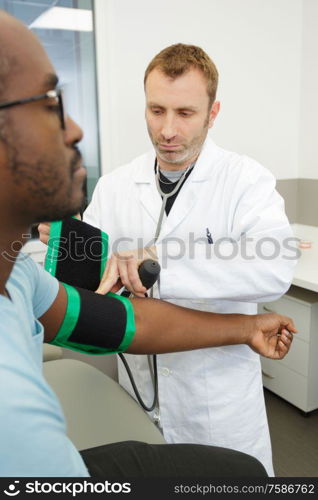 male doctor measuring blood pressure of patient
