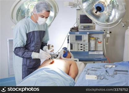 Male doctor performing operation on patient in operating room