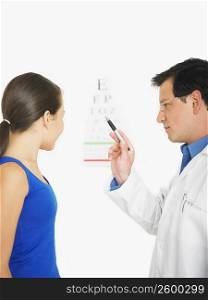 Male doctor showing the eye chart to a female patient