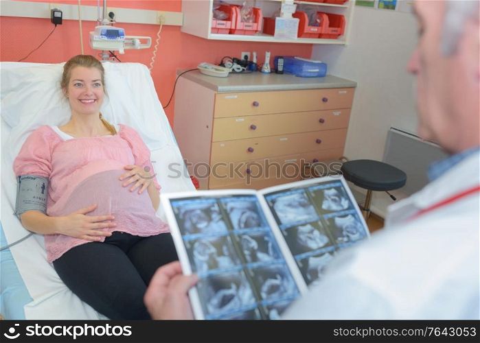 male doctor talking to a pregnant woman in hospital
