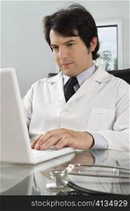 Male doctor using a laptop in a clinic