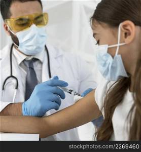 male doctor vaccinating girl close up