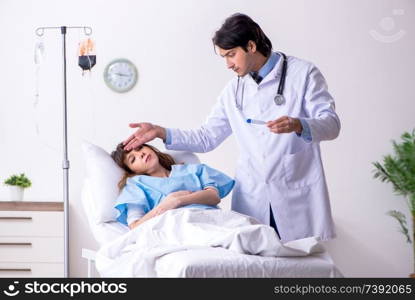 Male doctor visiting female patient in ward 