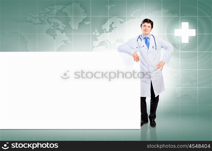 Male doctor with banner. Young male doctor leaning upon blank banner. Place for text