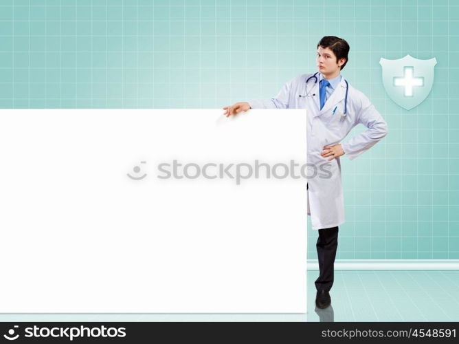 Male doctor with banner. Young male doctor leaning upon blank banner. Place for text