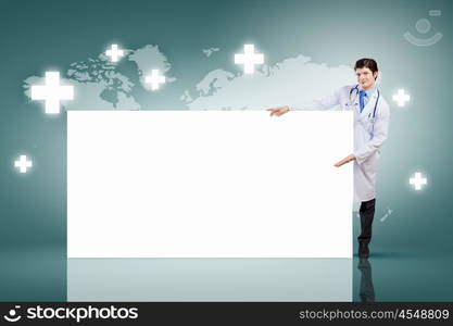 Male doctor with banner. Young male doctor leaning upon blank banner. Place for text