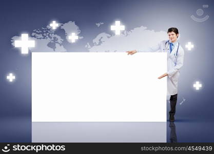 Male doctor with banner. Young male doctor leaning upon blank banner. Place for text