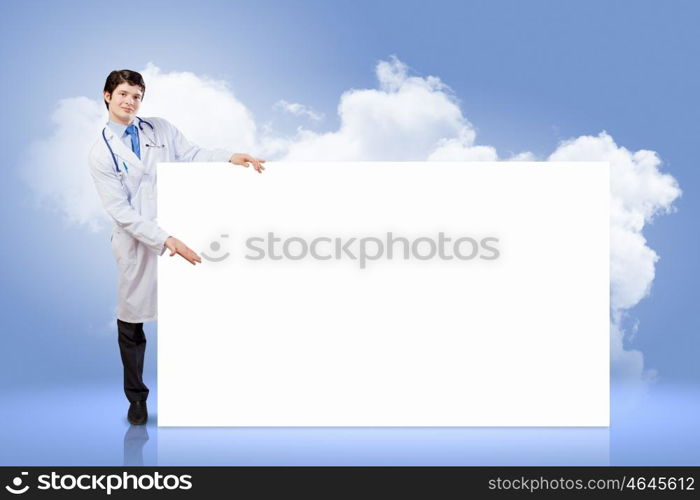 Male doctor with banner. Young male doctor leaning upon blank banner. Place for text