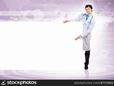 Male doctor with banner. Young male doctor leaning upon blank banner. Place for text