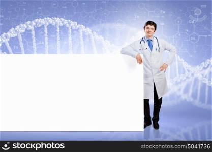 Male doctor with banner. Young male doctor leaning upon blank banner. Place for text