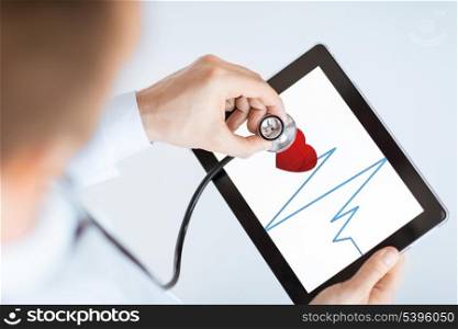 male doctor with stethoscope and tablet pc listening to heart beat