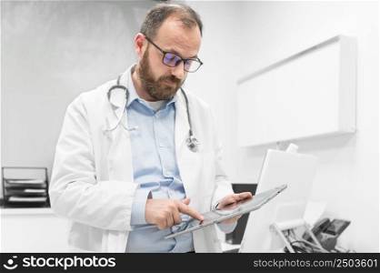Male doctor with white coat and stethoscope using tablet, network connection in hospital room, Medical technology network concept. High quality photography.. Male doctor with white coat and stethoscope using tablet, network connection in hospital room, Medical technology network concept