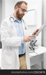 Male doctor with white coat and stethoscope using tablet, network connection in hospital room, Medical technology network concept. High quality photography.. Male doctor with white coat and stethoscope using tablet, network connection in hospital room, Medical technology network concept