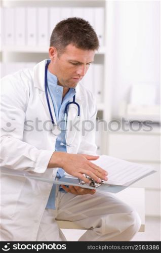 Male doctor working at office