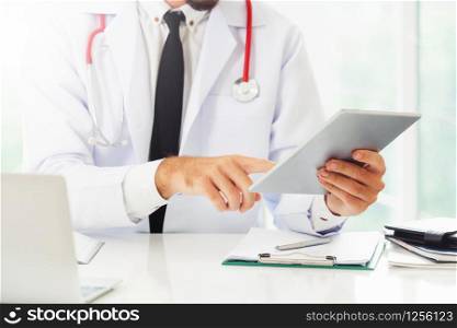 Male doctor working in hospital. Healthcare and medical service.. Doctor working on tablet computer in the hospital.