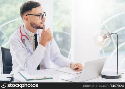 Male doctor working with laptop computer in hospital office. Healthcare and medical service.. Doctor working with laptop computer in hospital.