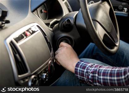 Male driver turning ignition key in right-hand drive car