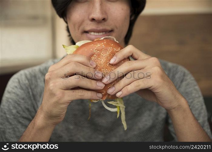 male eating hamburger cafe