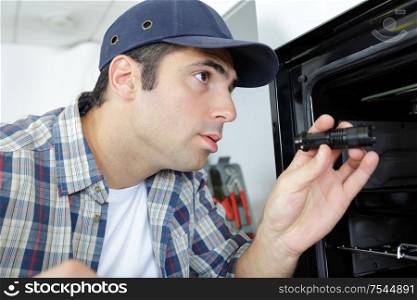 male electrician checking an oven