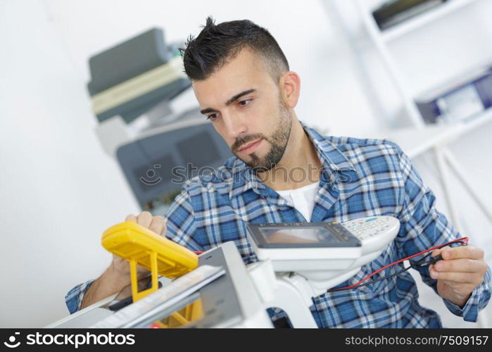 male electrician checking device with digital multimeter