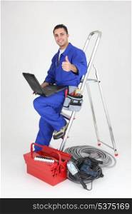 Male electrician with laptop and equipment