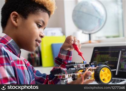Male Elementary School Pupil Building Robot Car In Science Lesson