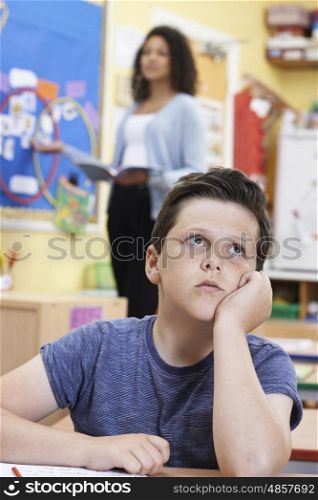 Male Elementary School Pupil Daydreaming In Class