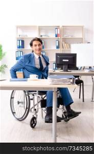 Male employee in wheelchair working at the office 