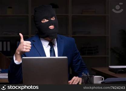Male employee stealing information in the office night time  