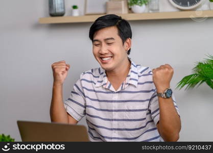 Male employee working in office with laptop and in good mood