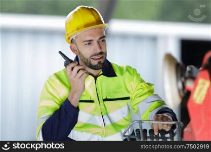 male engineer communicating on walkie-talkie at site