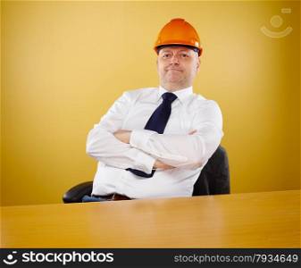 Male engineer in office, he wearing a white shirt and tie, head he wears a orange hard hat