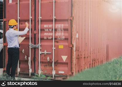 Male engineer inspection checking on container background With note on notepad or clipboard.Metaphor Quality inspection or Production speed image