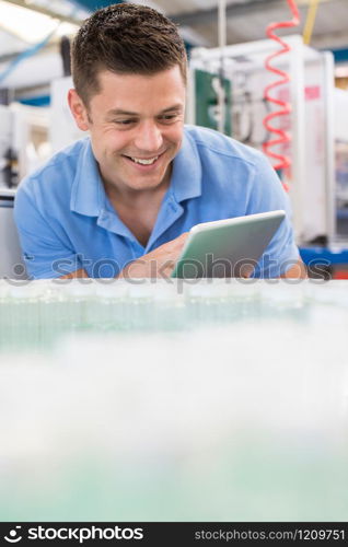 Male Engineer With Digital Tablet Working In Bottle Capping Factory