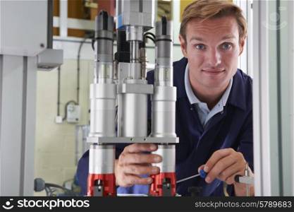 Male Engineer Working On Machine In Factory