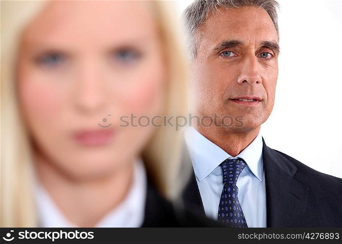 Male executive with female colleague out of focus in the foreground