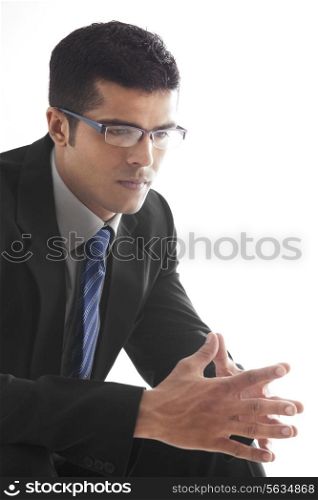 Male executive with hands clasped over white background