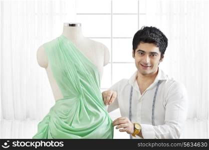 Male fashion designer working on dressmaker&rsquo;s form