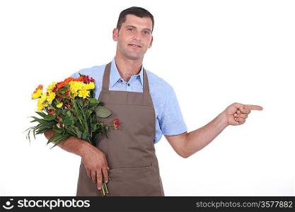 Male florist pointing out of shot