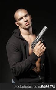 male gangster holding a gun isolated on black background