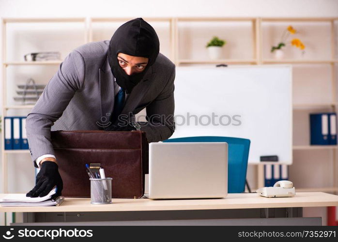 Male gangster stealing information from the office 