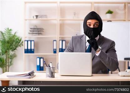 Male gangster stealing information from the office 
